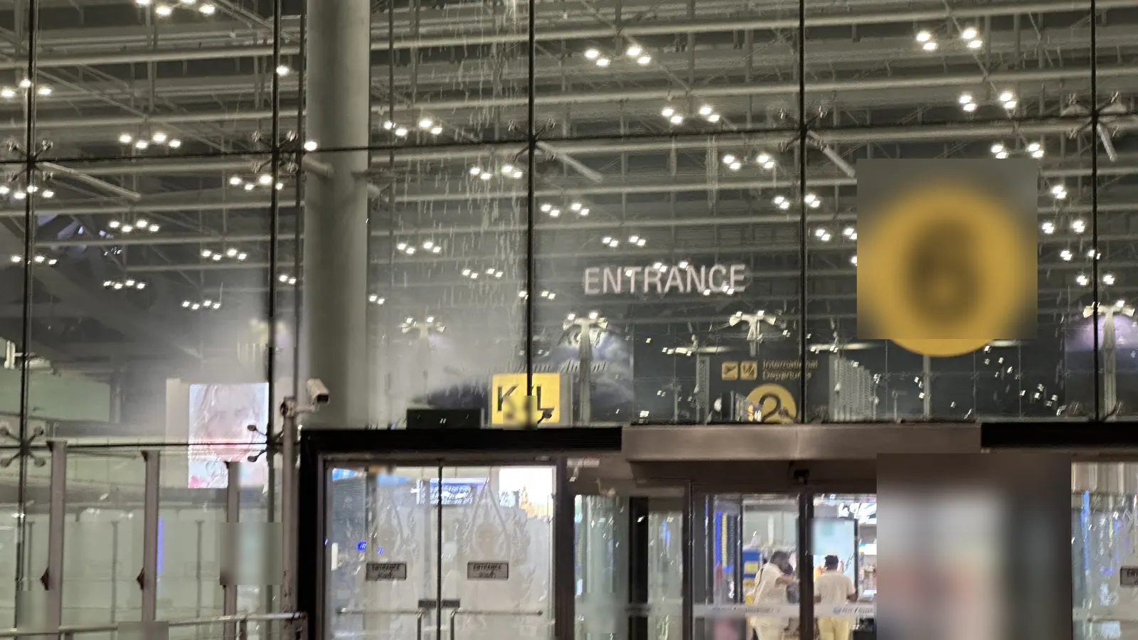 夜のスワンナプーム空港。ガラス越しに見える出発フロアの入口