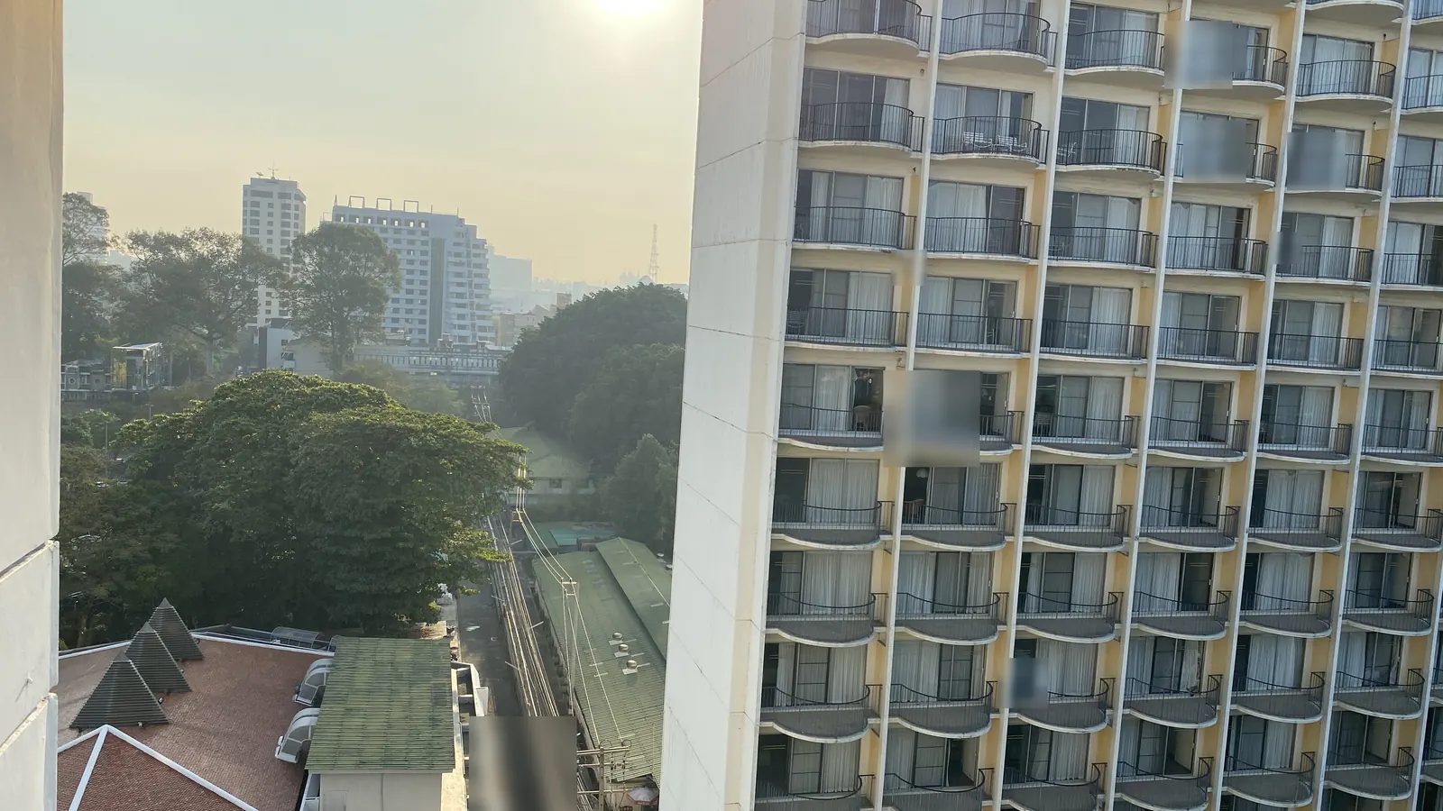 朝のバンコク。低層の街並みと、向かい合う高層コンドミニアムの外観